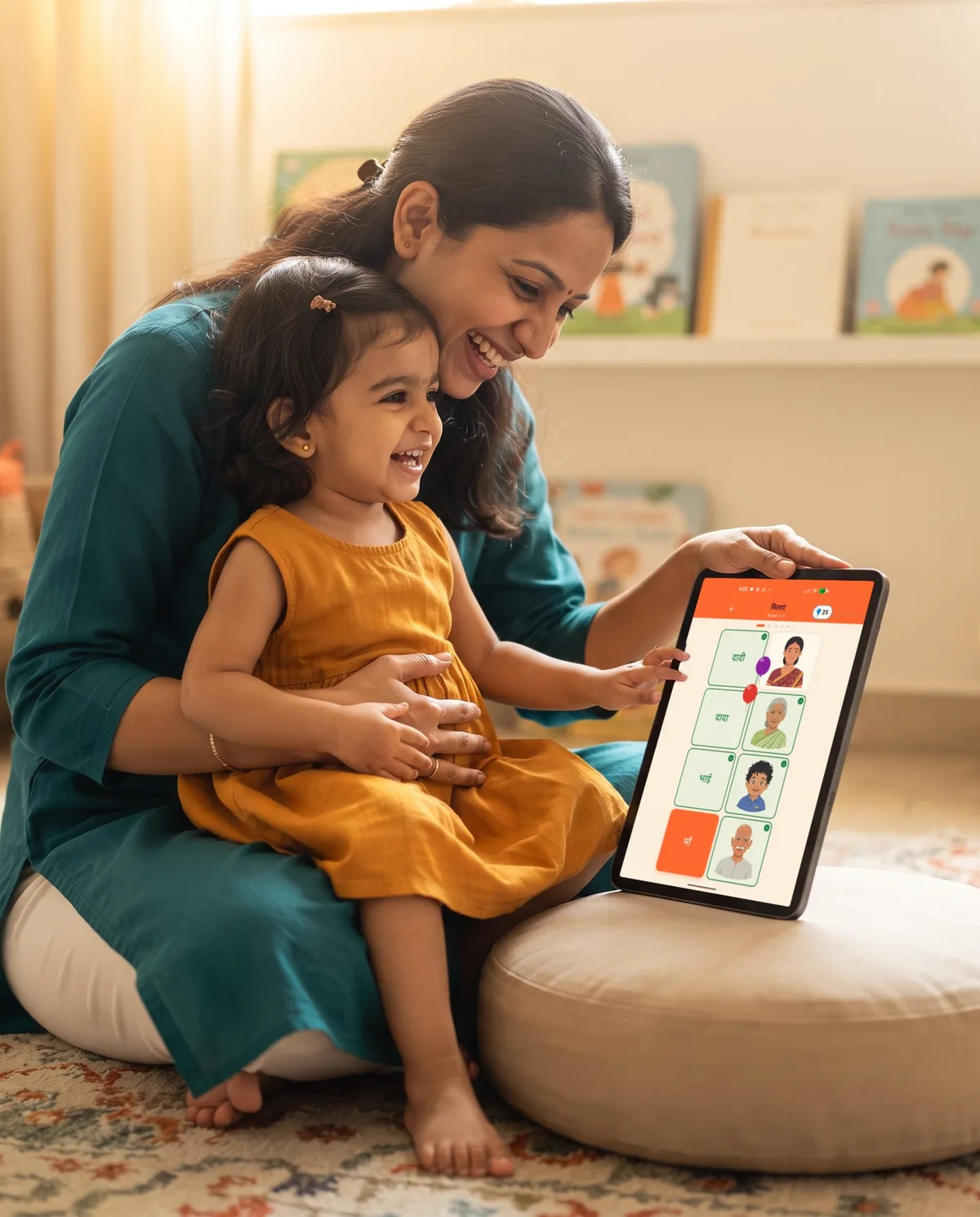 A mother and her toddler daughter on a nursery rug playing the Aksharamaala match game on an iPad